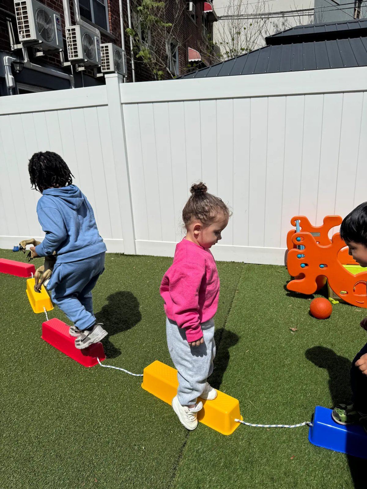 Children stepping along an outdoor obstacle course